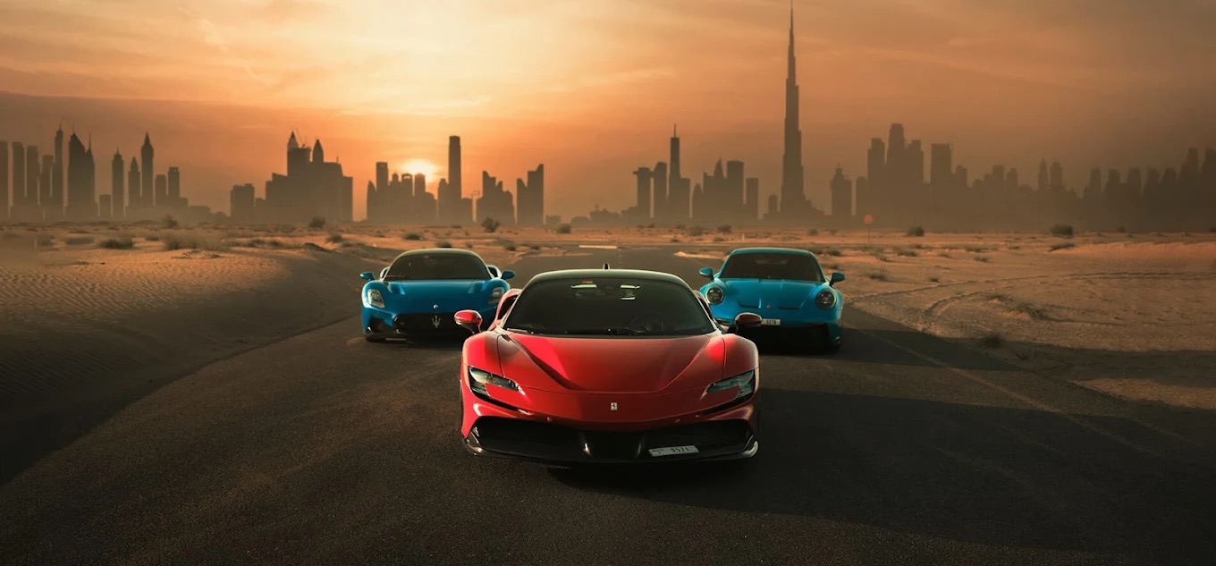 Sportsbiler foran Dubai-skylinjen i solnedgang